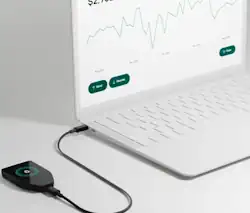 Trezor Hardware Wallet attached to laptop - image